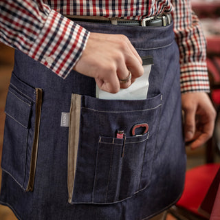 Man using his service apron with lots of storage and utility options. Sturdy denim fabric.