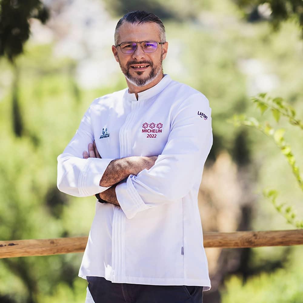 Three-star Michelin chef in a white chef jacket with long sleeves