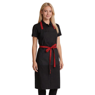Hospitality catering professional wearing a black bib apron with red adjustable neck strap and ties, a bib pocket, and a large twin-compartment pocket on the chest.