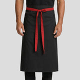 Hospitality worker wearing a black apron with a red waist ties 